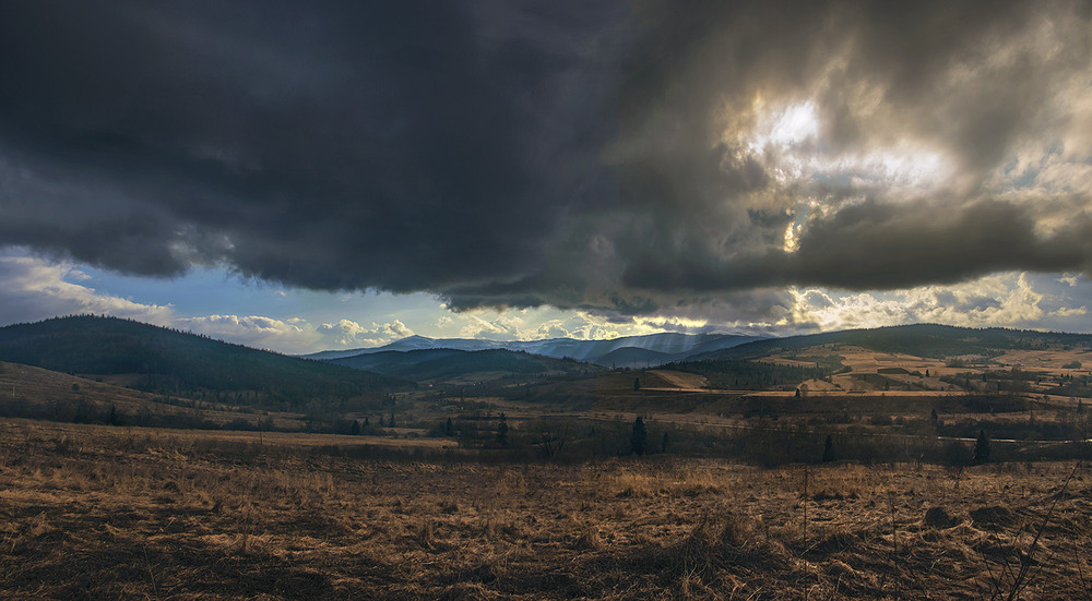Фотографія Між чорною хмарою з дощем і рудим карпаттям виникла шпаринка, в яку полилося вечірнє сяйво. / Юрій Максименко / photographers.ua